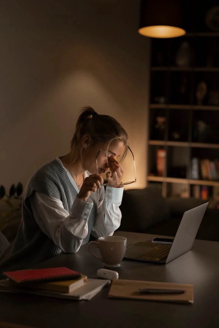 Criadora cansada, tentando organizar as ideias em frente ao notebook à noite